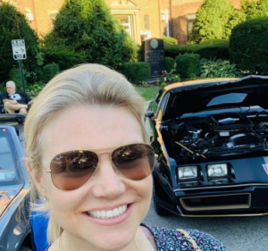 Heather Nauert posing for a photo with her car